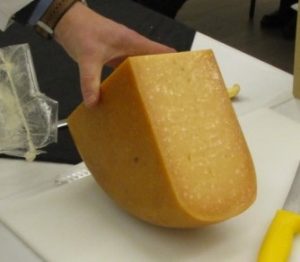 A block of aged cheese containing large crystals of calcium salts of tyrosine.