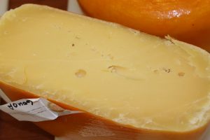A cross-section of a block of Gouda. Gouda is an example of semi-hard washed cheese.