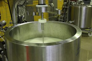 Milk sitting in a large metal vat